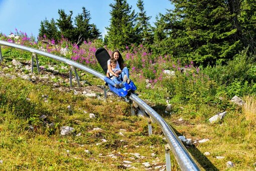 Mutter mit Kind auf Sommerrodelbahn